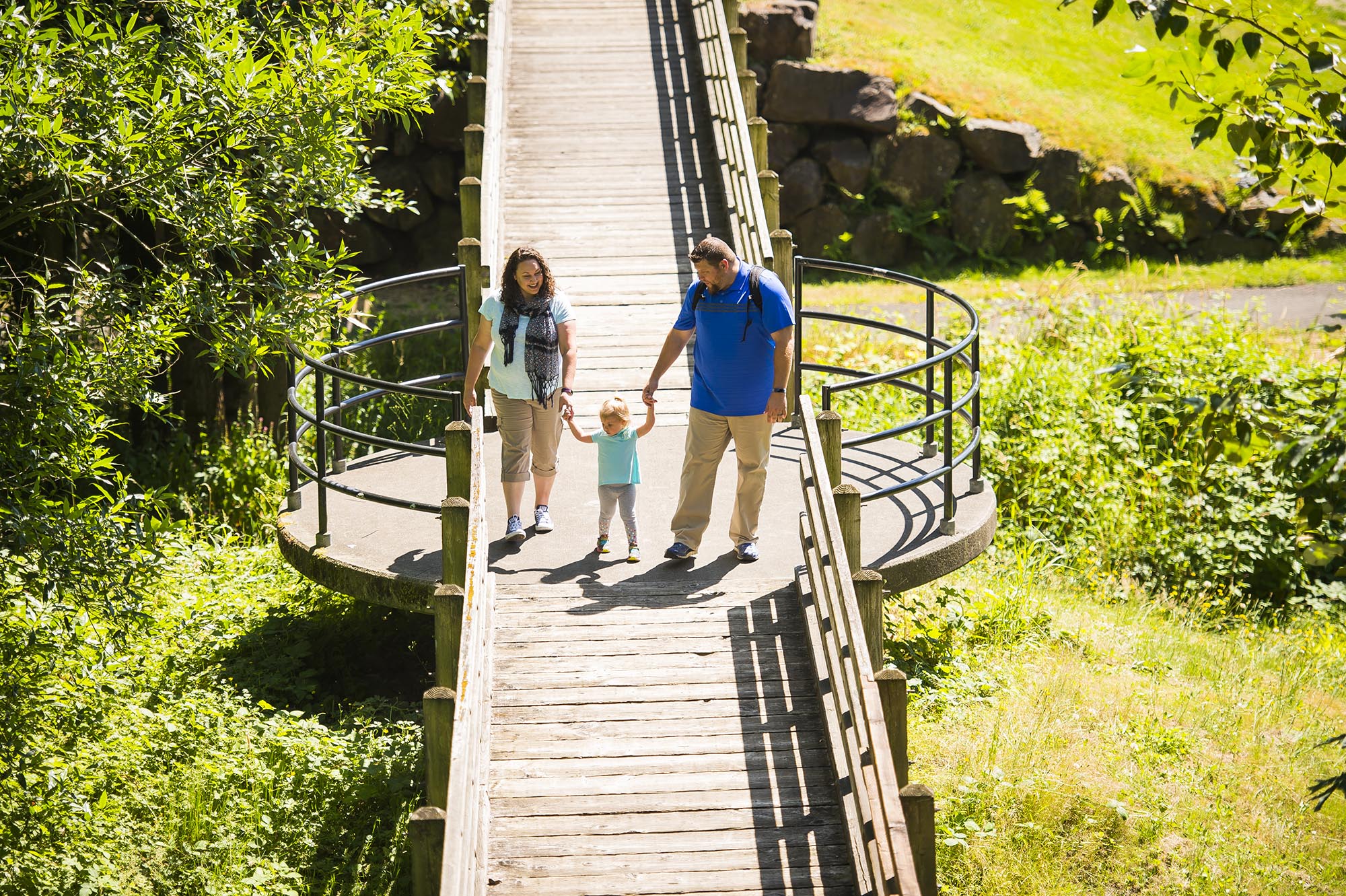 Family walking on bridge at Mill Creek Canyon Earthworks Park in Kent, Washington